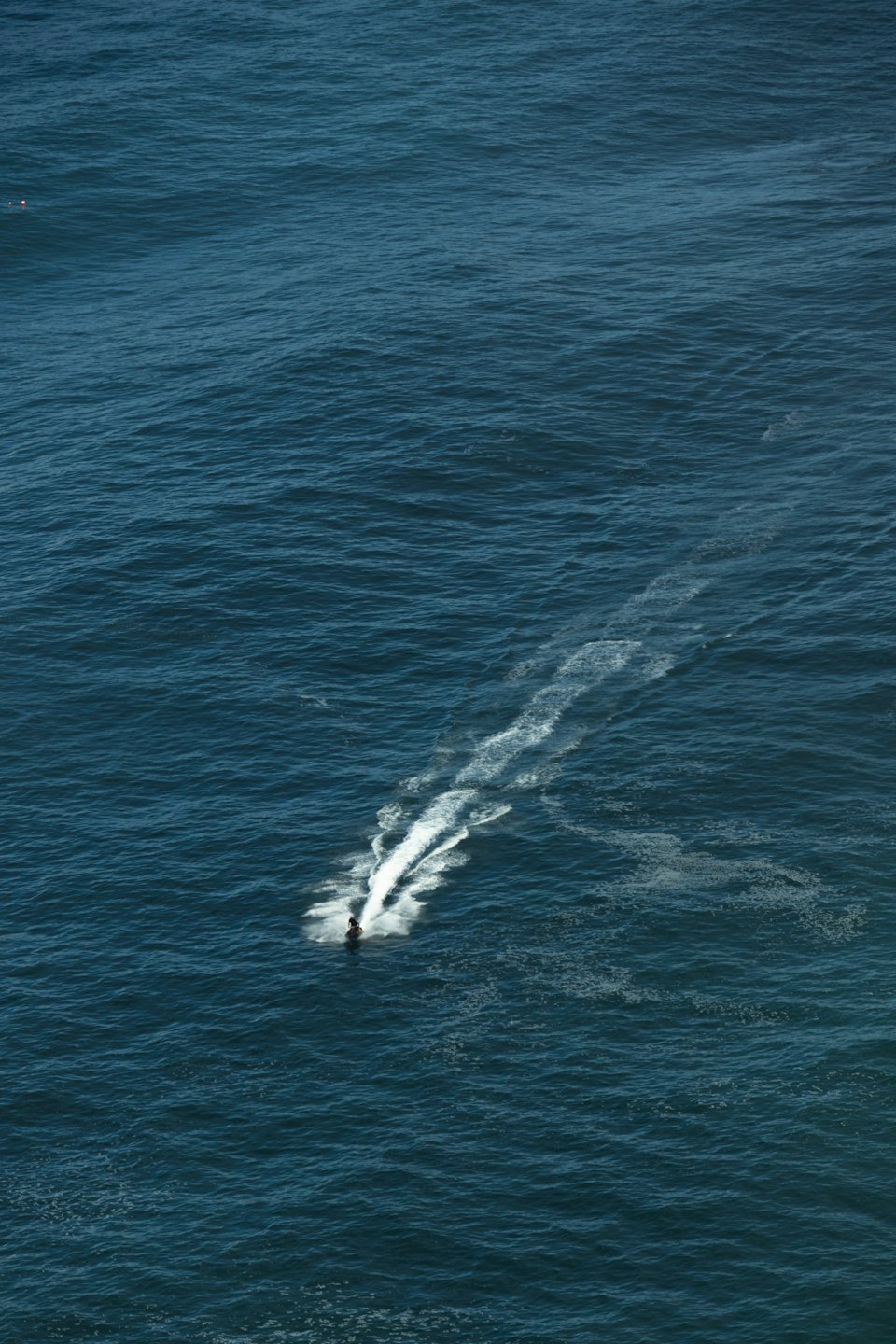 A person rides a jet ski across the open ocean.